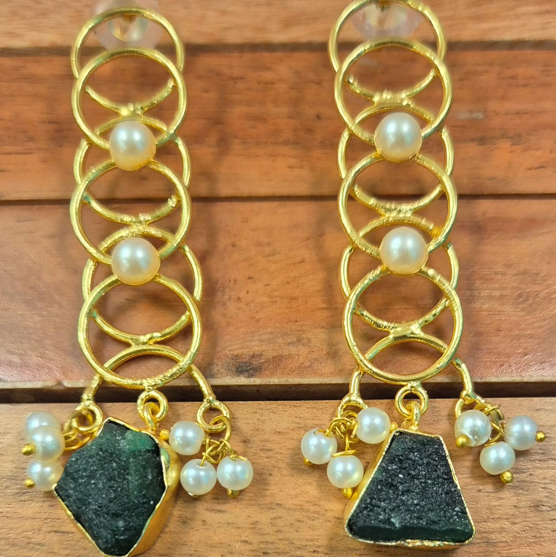 Long danglers in circular rings with green uncut stone