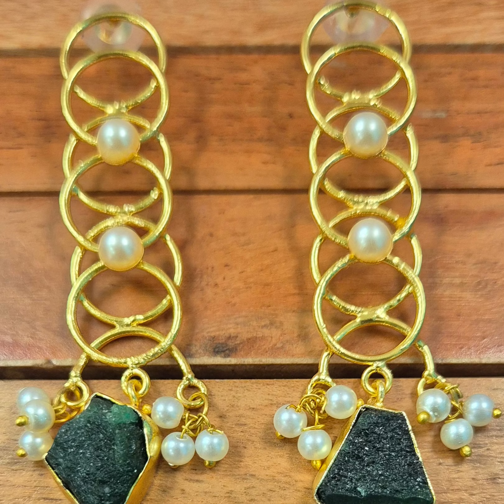 Long danglers in circular rings with green uncut stone