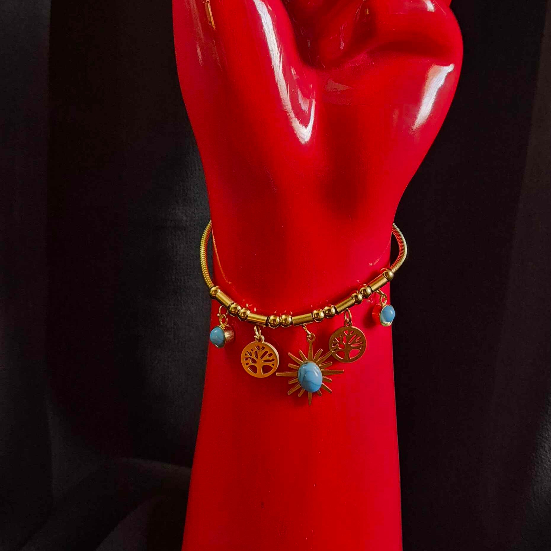 Gold-Tone Charm Bracelet with Blue Stone and Sunburst Pendant