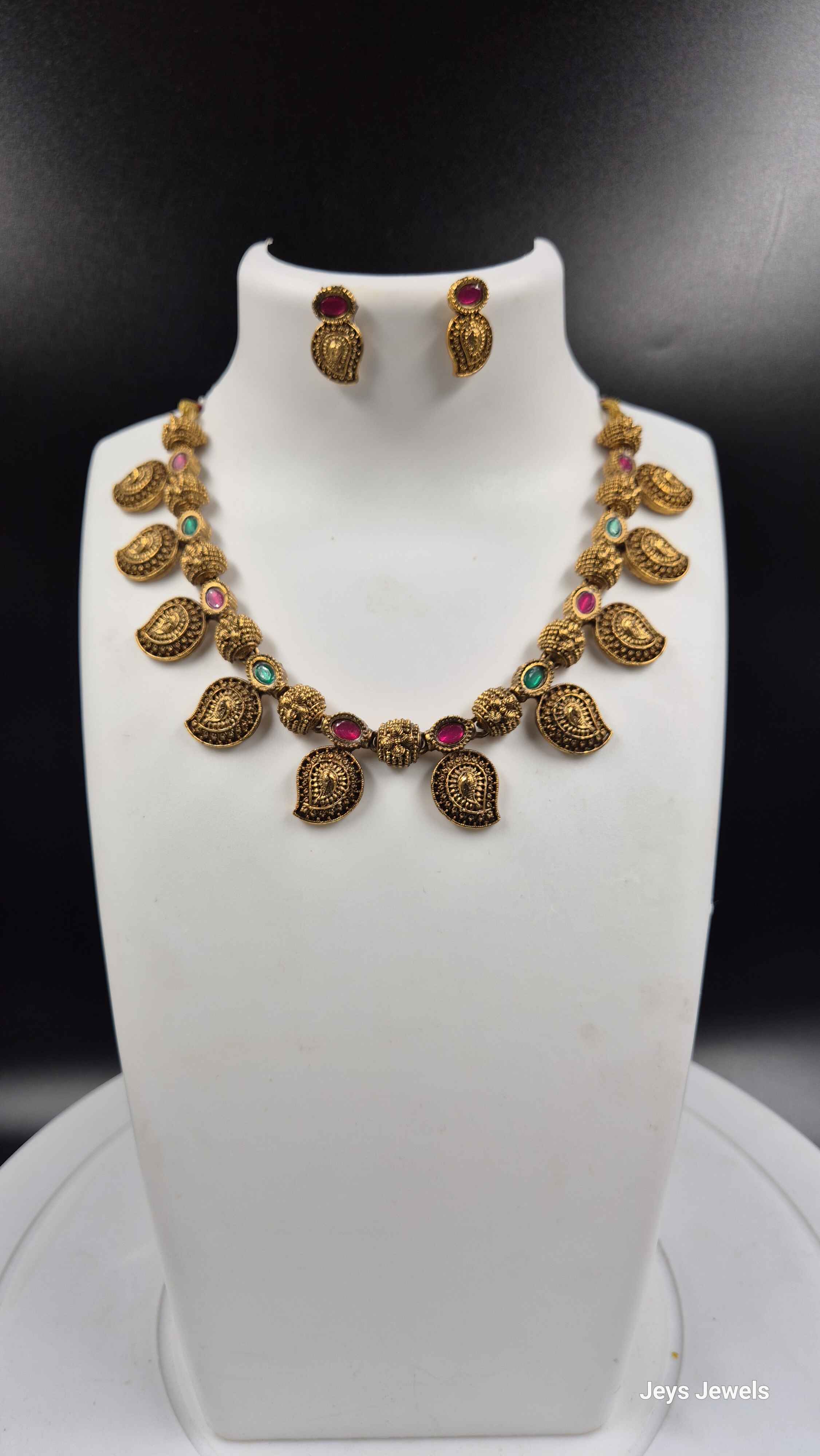 Traditional Mango necklace with green and red stones.
