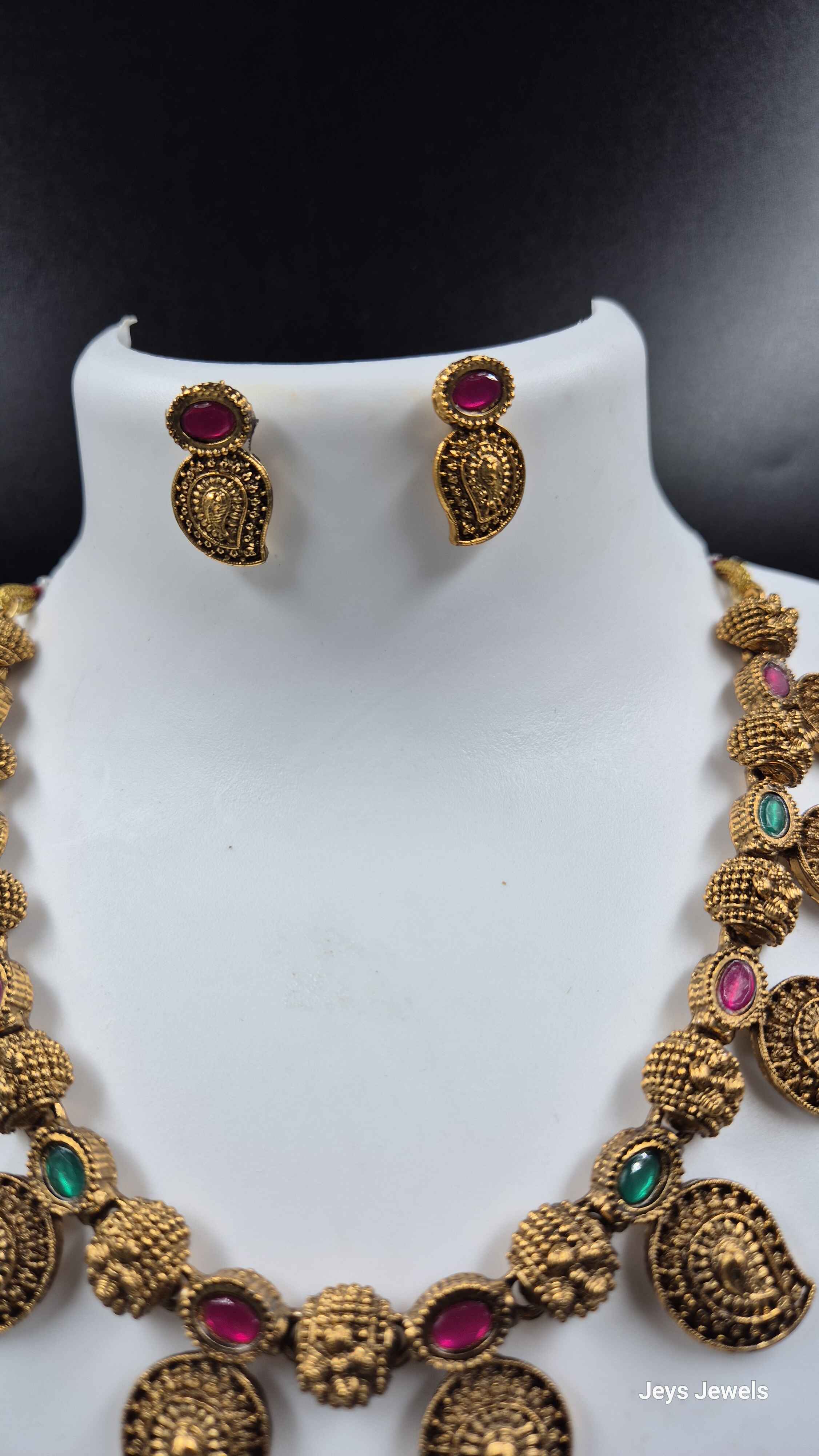 Traditional Mango necklace with green and red stones.